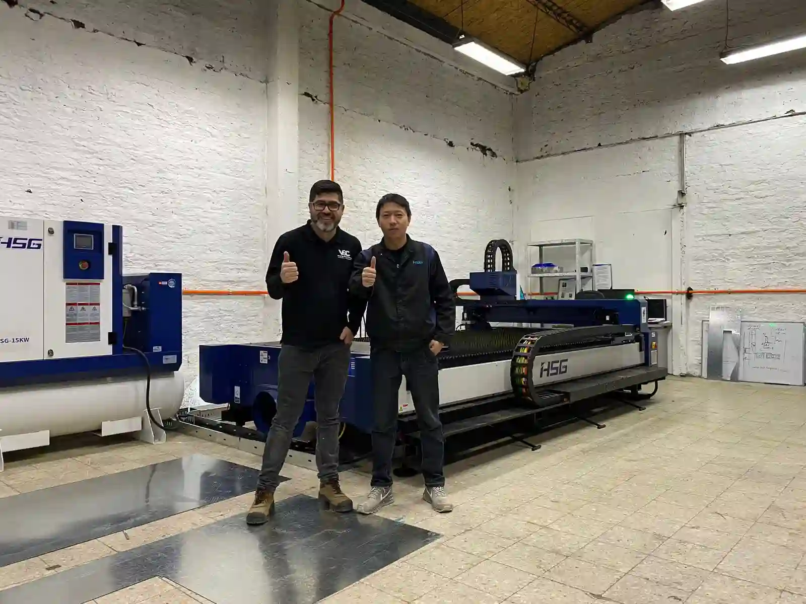 Técnicos junto a una máquina de corte láser de fibra en el taller